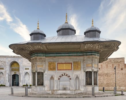 Fountain of Sultan Ahmed III, or Ahmet Cesmesi, a 17th century public Turkish rococo water fountain, or Sebil, located in the Great Square, beside the Imperial Gate of Topkapi Palace, Istanbul, Turkey