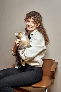 A cat in a woman's arms looks into her happy face