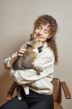 The concept of devotion, love and fidelity of a pet. Young woman hugs her kitten.