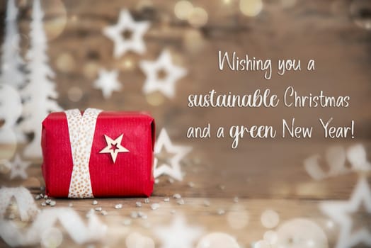 Text Wishing You A Sustainable Christmas And A Green New Year, With Christmas Gift, Wooden Background, Stars, Winter or Christmas Decoration
