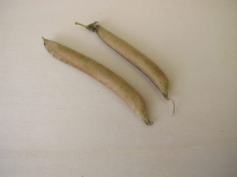 Ripe sweet pea pods on a wooden board