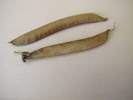 Ripe sweet pea pods on a wooden board