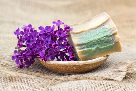 bar of natural soap and lilac flowers - aromatherapy