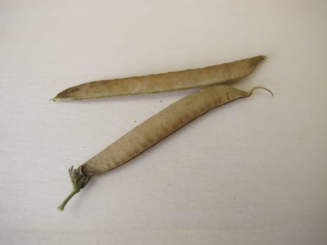 Ripe sweet pea pods on a wooden board