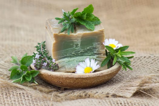 bar of natural soap, herbs and flowers