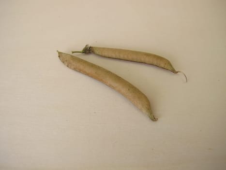 Ripe sweet pea pods on a wooden board
