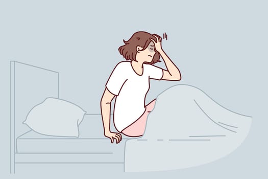 Woman woke up with nightmare and sits in bed holding head, in need of sleeping pills or psychological support. Nightmare caused insomnia and headache in girl suffering from terrible dreams