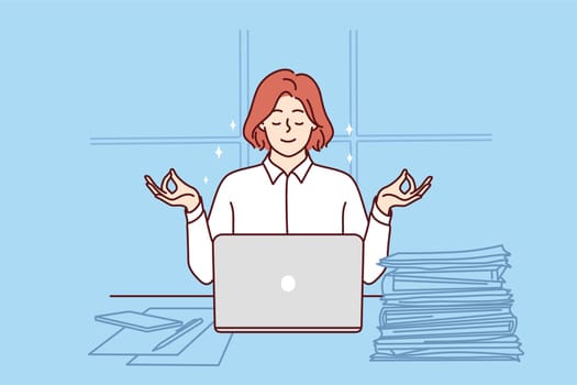 Business woman meditates sitting at office desk with papers and laptop and taking short break. Businesswoman meditates in lotus position and uses yoga practices to be more productive