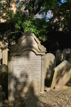 old weathered gravestones on a historical Jewish cemetery in Prague-Žižkov district