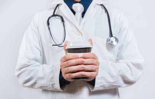 Hands of doctor holding takeaway coffee on isolated background. Doctor hands holding paper coffee
