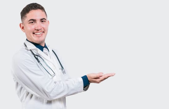 Happy doctor presenting something with his palms. Handsome doctor showing an advertisement with his palms