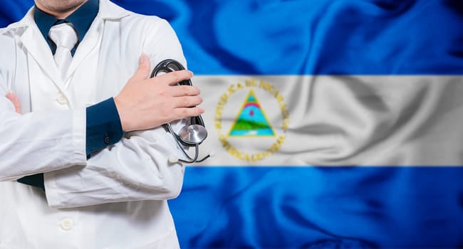 Doctor with stethoscope on flag of Nicaragua. Health and care concept with Nicaragua flag. Doctor with crossed arms on flag of Nicaragua