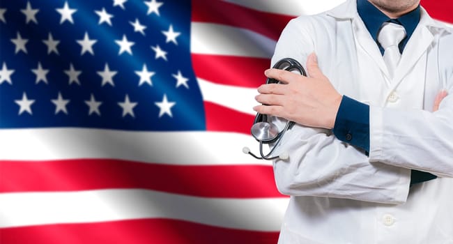 Doctor with stethoscope on American flag. Doctor with arms crossed on American flag, Health and care with the flag of United State