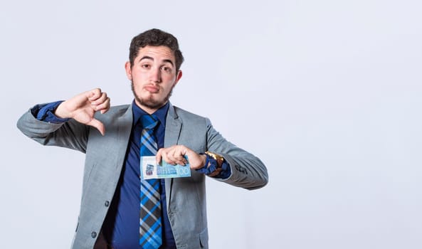 Business man holding banknote with thumb disapproving, man with money in hand and thumb down