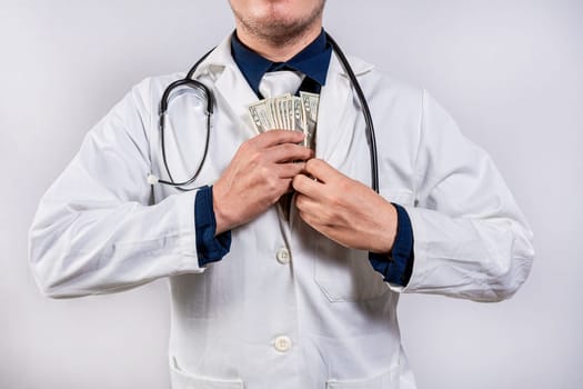 Dishonest doctor putting money in pocket. Medical bribery concept, Corrupt doctor putting bribe money in pocket isolated