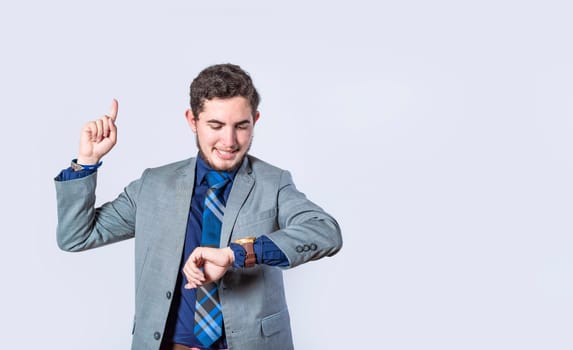 business man shocked with a new idea, surprised man in suit jacket pointing finger up, business man looking at his watch and pointing up