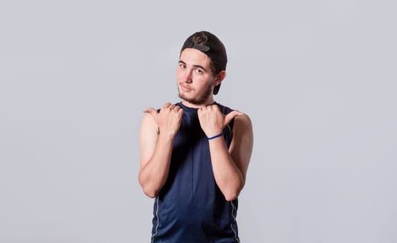 Handsome man pointing to the side, friendly guy pointing his fingers to the side, young man pointing at blank space