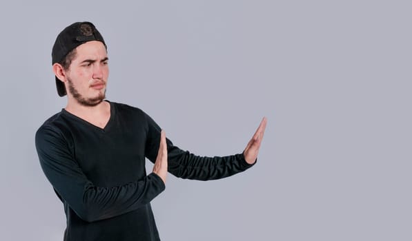 Disgusted intense man with rejection gesture, pulls palms in rejection, frowns in disgust