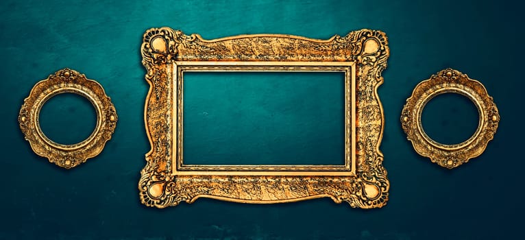 Vintage luxury golden frames set with ornate baroque decoration on rustic textured wall background. Retro fancy picture frames for interior design.