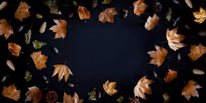 Autumn maple leaves frame on dark background with copyspace from above. November black friday sale and thanksgiving concept. Fall season natural flat lay border.