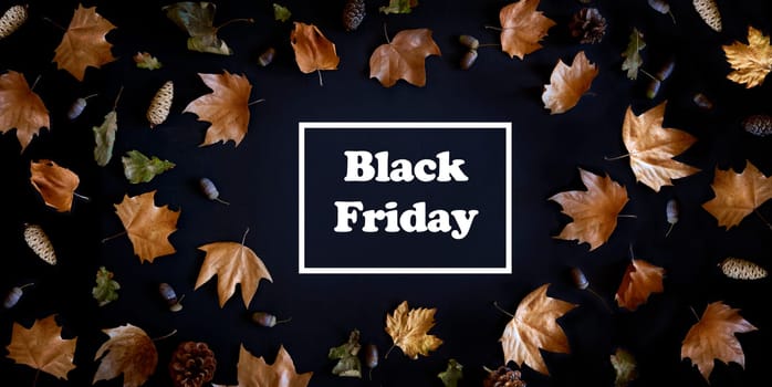 Autumn maple leaves frame on dark background with copyspace from above. November black friday sale and thanksgiving concept. Fall season natural flat lay border.