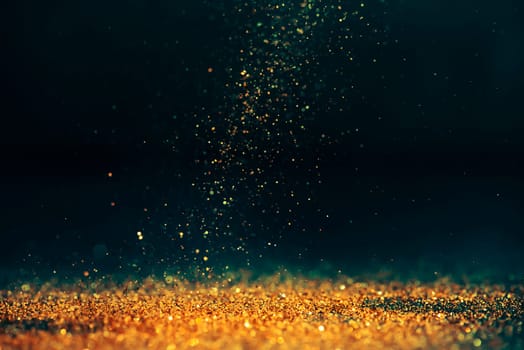 Luxury abstract glitter bokeh background. New year and christmas holiday party design. Golden star dust light sparkling on dark backdrop.