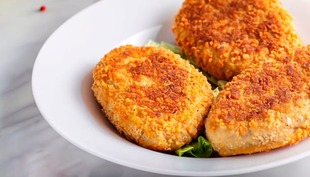 two chicken cutlets on a leaf of lettuce, mashed potatoes and tomato sauce. Kiev-style cutlets