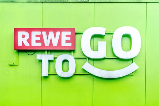 WETTENBERG, HESSE, GERMANY - 07 - 28 - 2023: REWE TO GO on a green house facade. Fast. Fresh. Food.