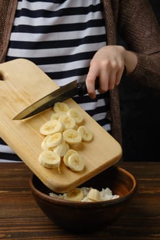 Drop sliced banana into a bowl with cottage cheese