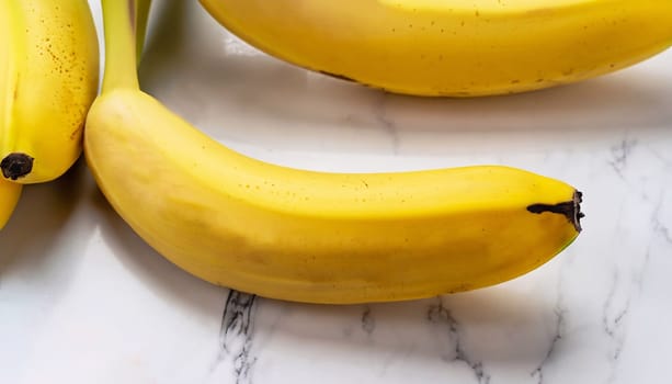 Woman's hand holding rotten, overripe bananas on white marble background. Spoiled food disgust. Horizontal orientation. Flat lay. Food waste concept