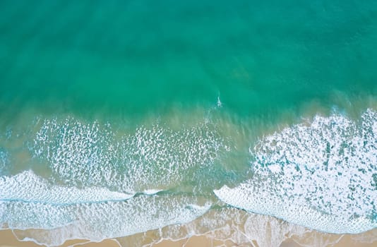 Aerial view of sandy beach and ocean with waves