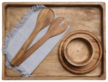 Empty bowl and wooden spoons on a black table, top view