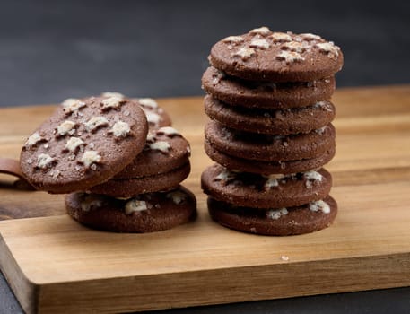 Stack of round chocolate cookies on a black background