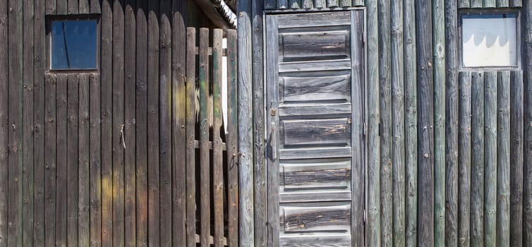 Weathered wooden walls built with logs. Long format