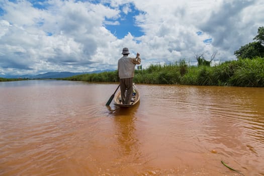 The Inle Lake. Myanmar: 17 August 2020: Fisherman rowing boat on Inle Lake, Myanmar. Inle Lake is famous for its floating villages and gardens.