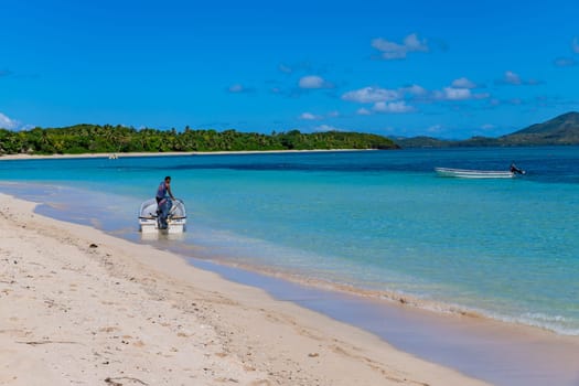 Nacula Fiji: June 25 2023: Man in a boat on the beach waiting for tourists, Yasawa Island group in Fiji