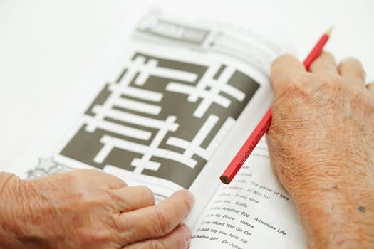Asian elderly woman playing sudoku puzzle game for treatment dementia prevention and Alzheimer disease.