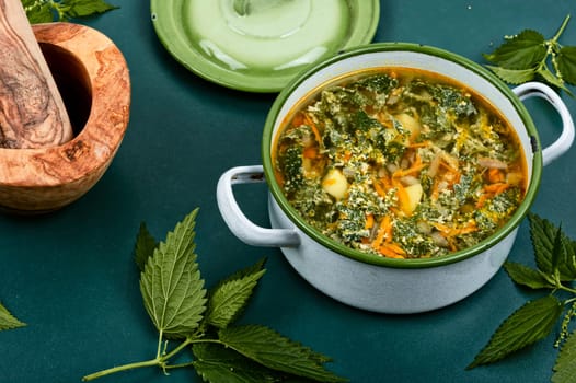 Nettle soup in a saucepan. Stinging nettle soup. Healthy food, copy space.