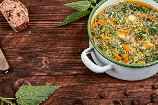 Nettle soup in a saucepan. Stinging nettle soup. Healthy food, copy space.