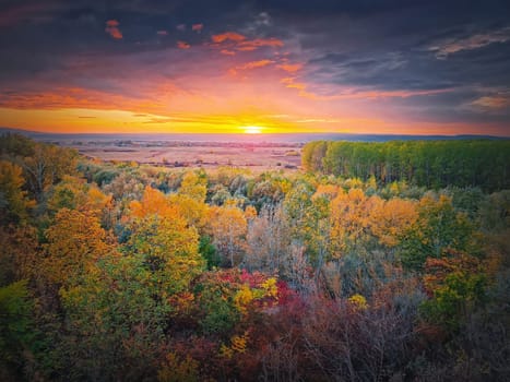 Colorful autumn landscape. Beautiful sunset over the valley with the multicolored woods. Idyllic fall season scenery