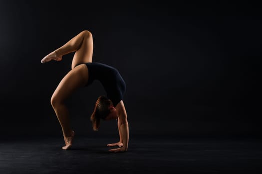 Portrait of a beautiful young woman gymnast training calilisthenics exercise with acrobatic element