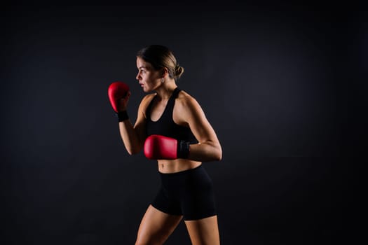 Young woman athletic female MMA fighter is training. Concept of sport, action, healthy lifestyle.