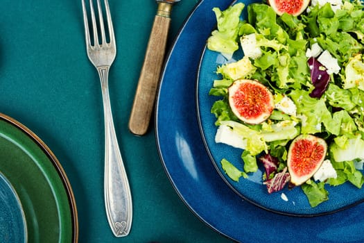 Vitamin salad of greens, ripe figs and diet cheese. Food background