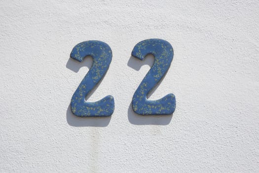 House number 22. Painted iron over whitewashed wall. Houses with personality concept
