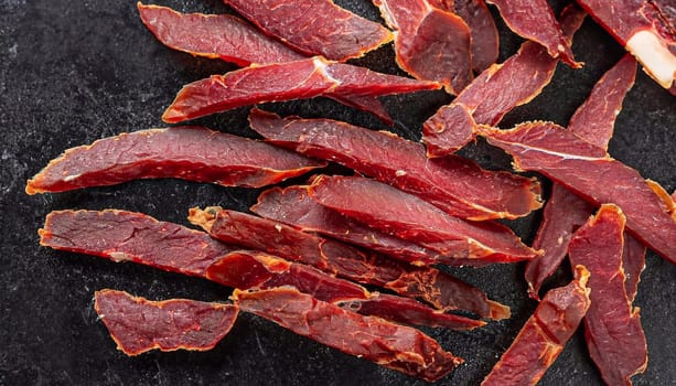 delicious jerky on a wooden background. products in craft packaging. snack for alcohol. macro photo. close-up