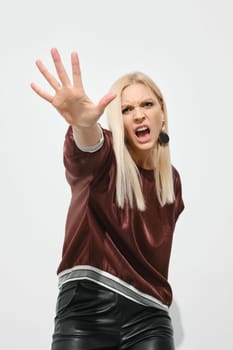 Woman stretches her palm forward, stopping gesture, protest