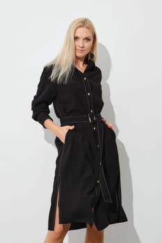 Cute woman in button down dress with hands in pockets