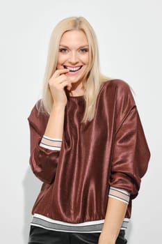 Beautiful happy blonde woman smiling with expression thinking about pleasant things