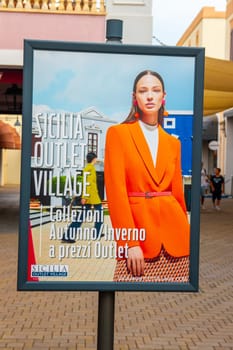 AGIRA, SICILY, Italy - 30 SEP 2023. Sicilia Outlet Village shopping centre near Agira town is a popular visitor magnet for holidaymakers and locals alike. Advertisement Image.