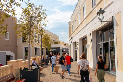 AGIRA, SICILY, Italy - 30 SEP 2023. Sicilia Outlet Village shopping centre is a popular visitor magnet. Passage with people where shopping at Outlet Village.